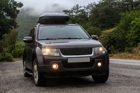SUV with a roof rack in a mountainous wooded area.Traveling by carの写真素材