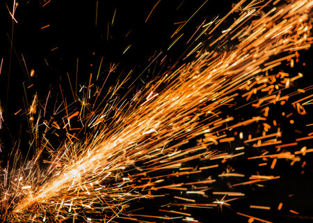 bright sparks of metal against dark backgroundの写真素材