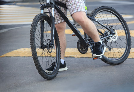 Guy on a bicycle at a pedestrian crossing close-up detail