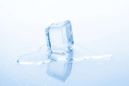 Cube of frozen ice is melting isolated on white backgroundの写真素材