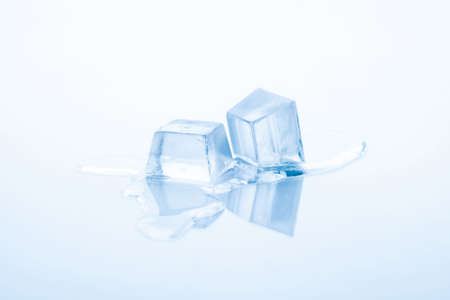 Two cubes of frozen ice are melting isolated on white backgroundの写真素材