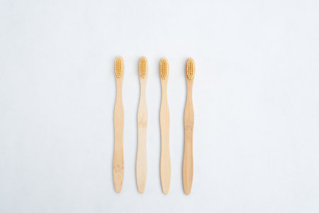 A family set of wooden bamboo toothbrushes on white backgroundの写真素材