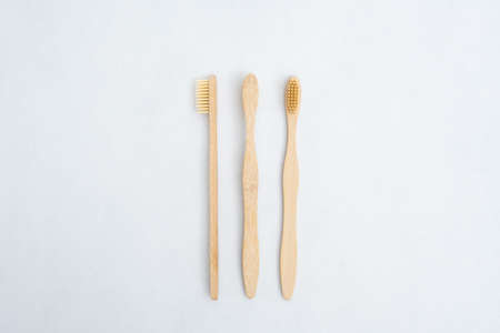 A family set of wooden bamboo toothbrushes on white backgroundの写真素材