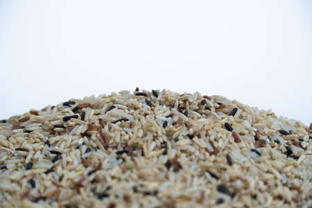 Heap of brown rice on white backgroundの写真素材