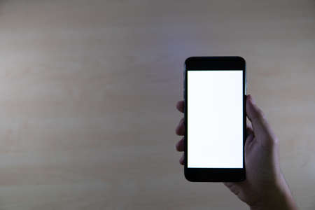 Smartphone mockup image of a man hand holding black mobile phone with white blank screenの写真素材