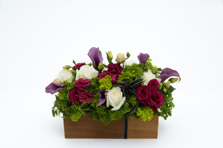 Beautiful fresh flowers bouquet in wooden gift box on white background for special day celebrationの写真素材