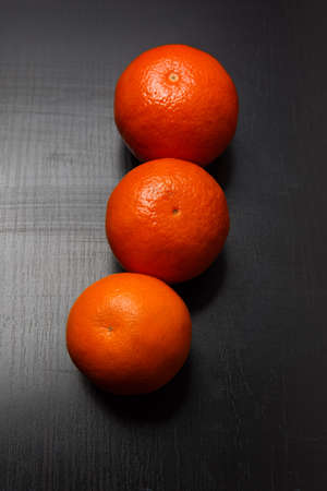 Fresh whole orange tangerines on black tableの写真素材