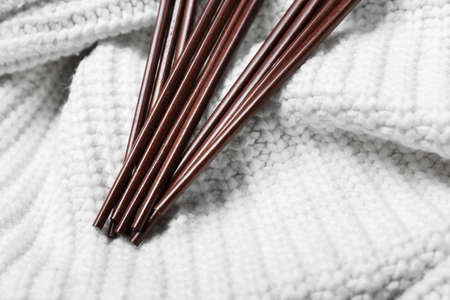Brown chinese wood chopsticks on white wool textureの写真素材