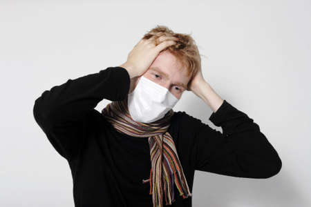Man with a headache, suffering from flu, A(H1N1), on the grey backgroundの写真素材