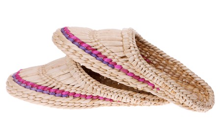 Old Russian sandals made of bark on the white backgroundの写真素材