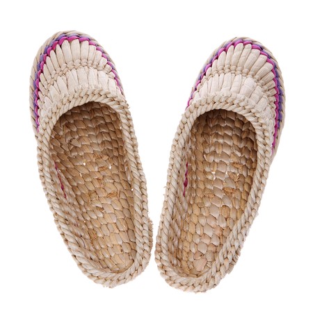 Old Russian sandals made of bark on the white backgroundの写真素材