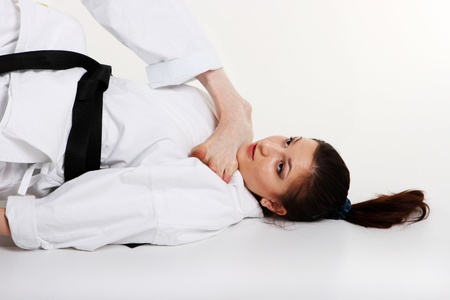 Karate. Young girl in a kimono with a white background. Sportswoman doing sports captureの写真素材