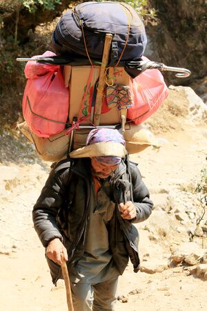 HIMALAYAS, NEPAL - APRIL 01: Porters carry heavy load in the Himalaya on Aprel 01, 2014 in Everest region, Nepalのeditorial素材