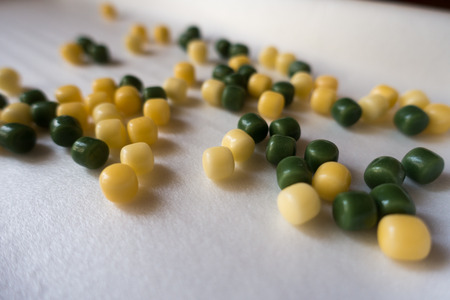 Small yellow and green candy dropsの写真素材