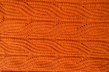 Bright orange handmade knit fabric with plait pattern