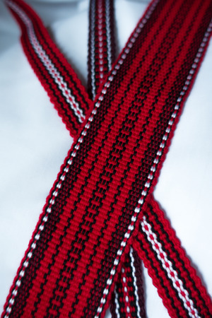 Three crossed woven tapes in with ethnic pattern in red, purple, black and whiteの写真素材