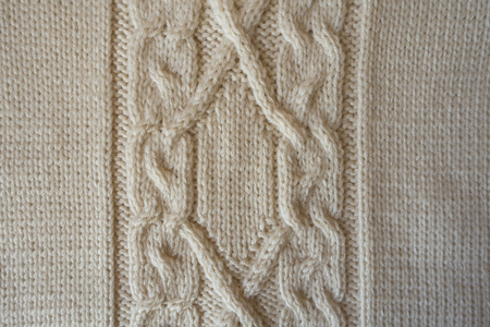 Beige handmade textile with vertical cable knit pattern from above