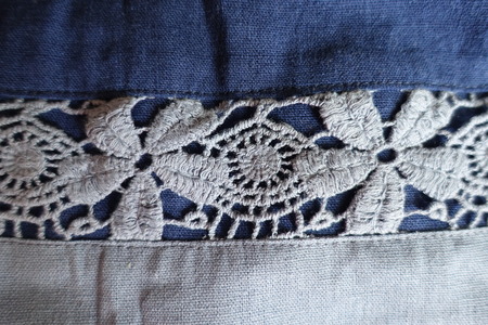 Stripe of lacy flowers on blue linen fabric (horizontal)の写真素材