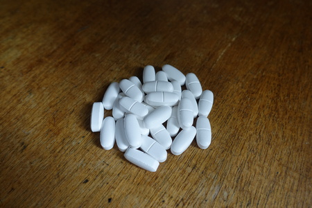 Caplets of calcium citrate on wooden table