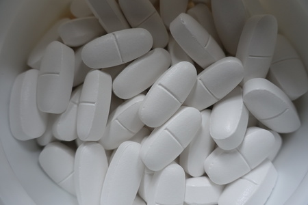 Container with big white calcium citrate tablets