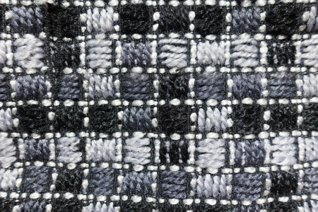 Surface of grey embroidered checkered fabric from above