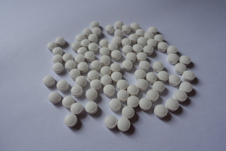Numerous small white tablets of vitamin K2
