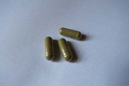Closeup of three capsules of moringa dietary supplement
