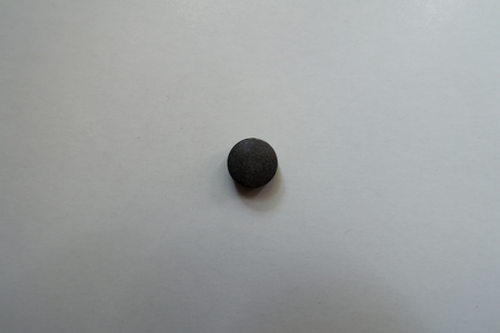 View of round black pill of chelated iron from aboveの写真素材