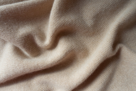 Soft folds of simple beige knitted fabricの写真素材