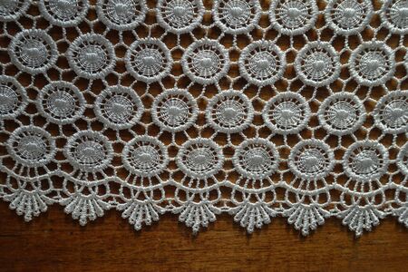 Cream white crochet lace edge on wooden table