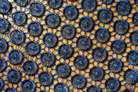 Very dark blue crochet lacy fabric on wood from above