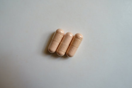Close view of three pink capsules of probiotic dietary supplementの写真素材