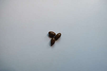 3 glossy brown softgel capsules of vitamin D3