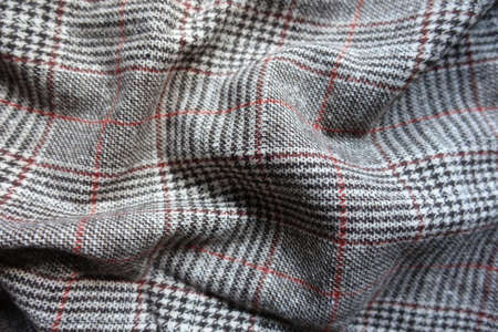 Red and grey Glen check woolen fabric in soft folds