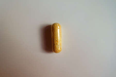 1 orange cellulose capsule of multivitamins from aboveの写真素材