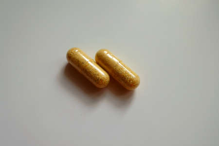Pair of orange cellulose capsules of multivitaminsの写真素材
