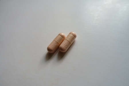 Identical two pink capsules of probiotic dietary supplement