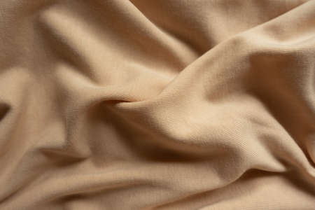 Beige cotton jersey fabric in soft foldsの写真素材