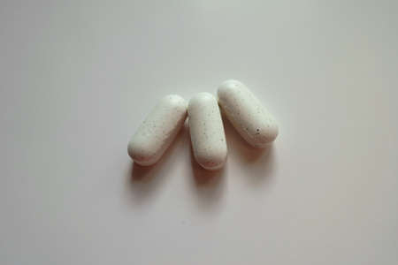 Close view of three white caplets of kelp dietary supplement