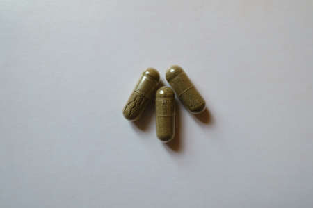 Three greenish brown capsules of iron bisglycinate from above