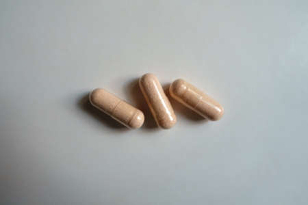 Top view of three pink capsules of probiotic dietary supplement