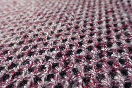 Close view of thick pink, grey and white woolen fabric with diamonds patternの写真素材