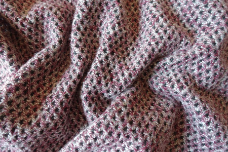 Folded thick pink, grey and white woolen fabric with diamonds pattern