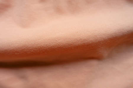 Soft fold on apricot colored simple cotton jersey fabricの写真素材