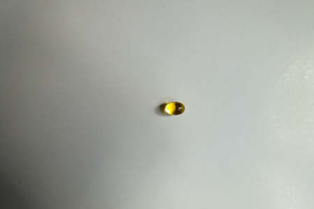 1 yellow softgel capsule of vitamin A (retinyl palmitate) from aboveの写真素材