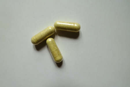 Top view of three yellowish green capsules of quercetin dietary supplementの写真素材