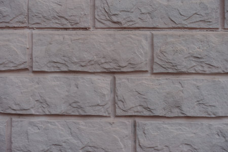 Macro of grayish pink painted brick veneer wall