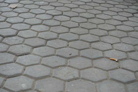 Dirty surface of gray concrete pavement with honeycomb geometric pattern