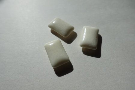 Close shot of three white rectangular pieces of chewing gum