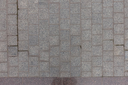 Top view of pavement made of gray unpolished granite stone blacks